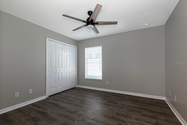 unfurnished bedroom with ceiling fan, a closet, and dark wood-type flooring