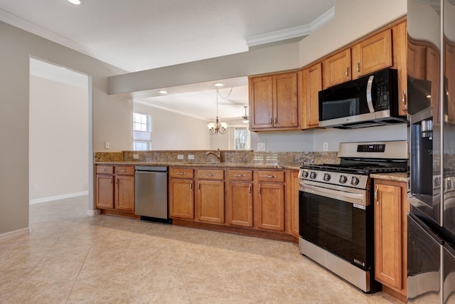 kitchen featuring light stone countertops, appliances with stainless steel finishes, an inviting chandelier, and ornamental molding