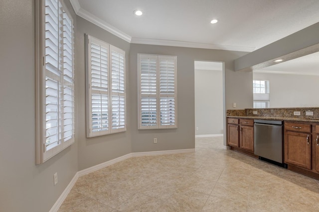 kitchen featuring dark stone countertops, dishwasher, light tile patterned flooring, and ornamental molding