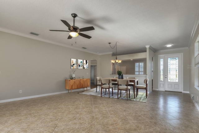 tiled dining room featuring a textured ceiling, ceiling fan with notable chandelier, and crown molding