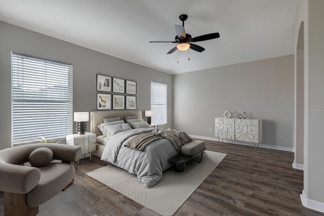 bedroom featuring multiple windows, dark hardwood / wood-style flooring, and ceiling fan