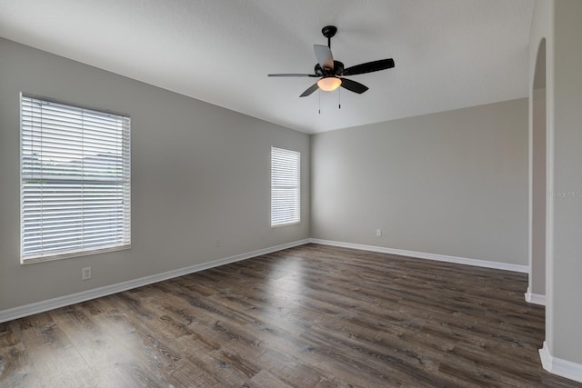 unfurnished room with ceiling fan and dark wood-type flooring