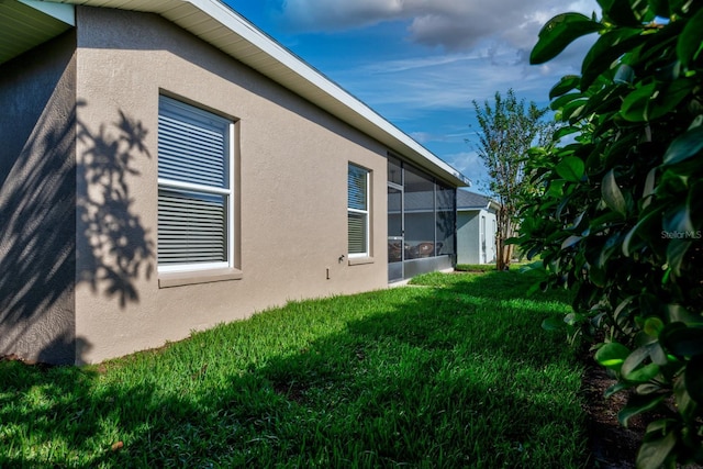 view of home's exterior with a lawn and a sunroom