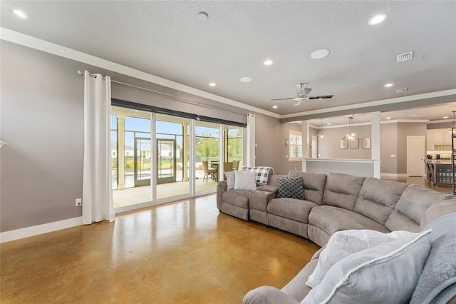 living room with ceiling fan, a textured ceiling, and crown molding