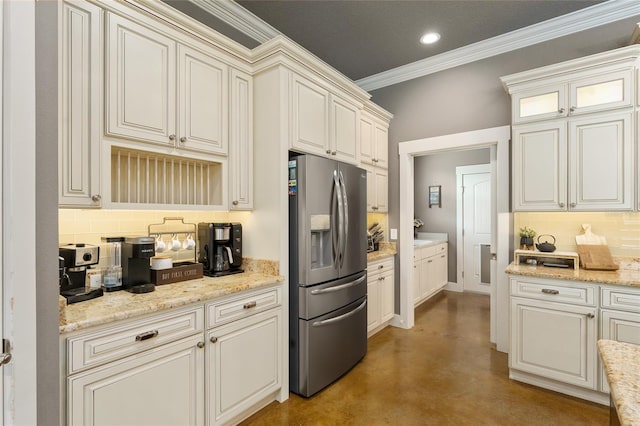 kitchen featuring light stone counters, ornamental molding, stainless steel fridge with ice dispenser, and decorative backsplash