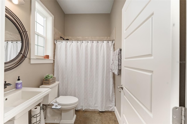 bathroom featuring sink, toilet, and curtained shower