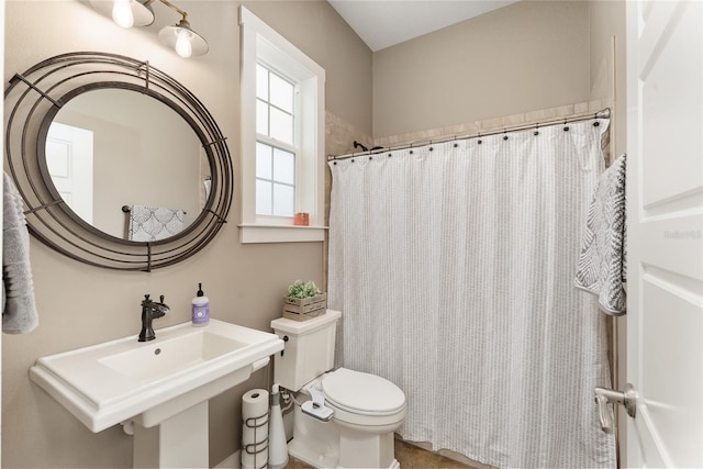 bathroom with sink, walk in shower, and toilet