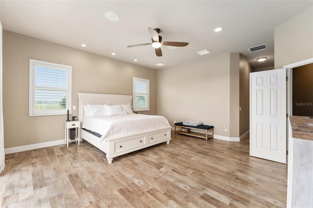 bedroom featuring light wood-type flooring, multiple windows, and ceiling fan