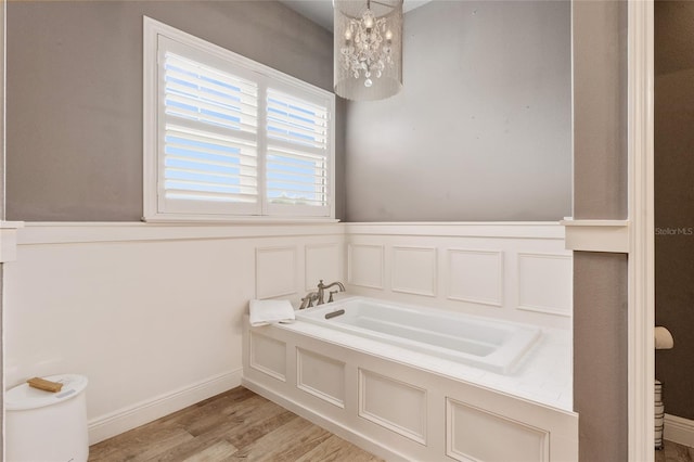 bathroom with wood-type flooring, a bathing tub, and toilet