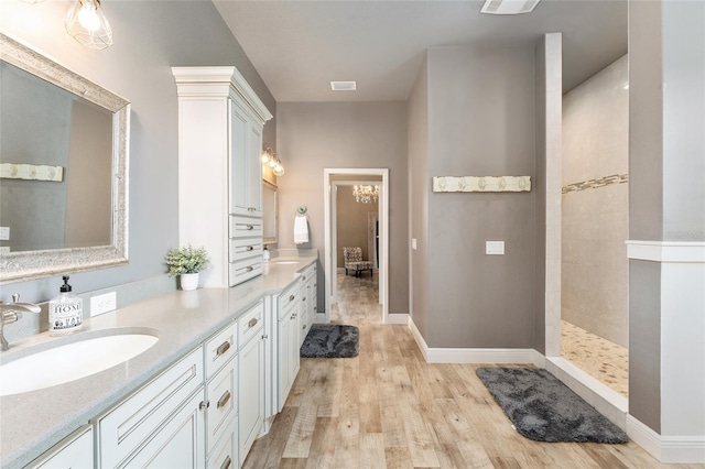 bathroom featuring vanity, tiled shower, and hardwood / wood-style floors