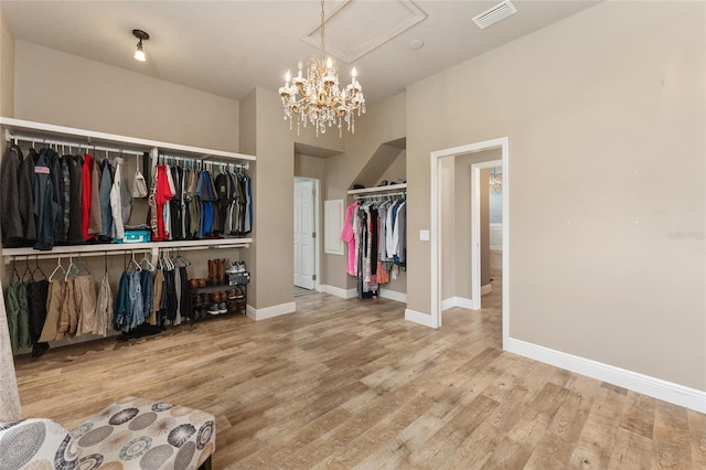 spacious closet featuring a towering ceiling and hardwood / wood-style floors