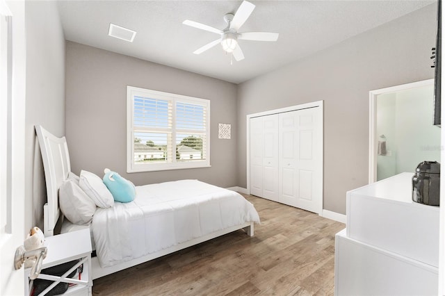 bedroom featuring ceiling fan, a textured ceiling, light hardwood / wood-style flooring, and a closet