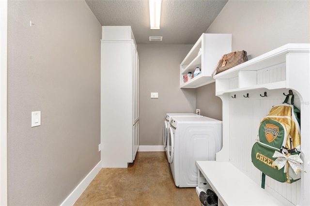 mudroom featuring light colored carpet, a textured ceiling, and washing machine and clothes dryer