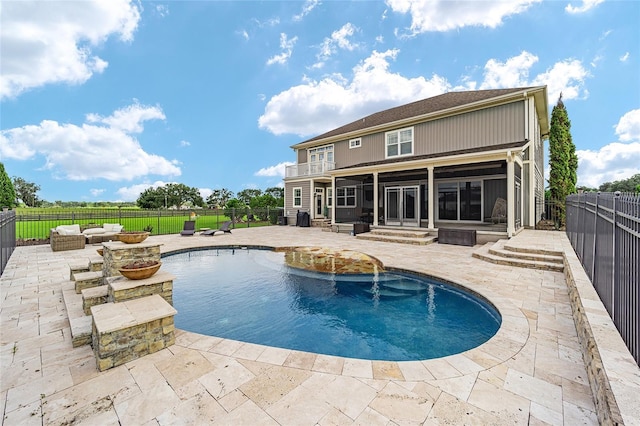 view of pool with an outdoor living space, a sunroom, and a patio area