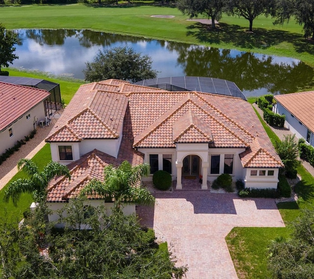 view of front of home featuring a front lawn, a water view, and glass enclosure