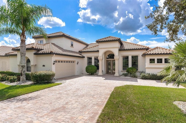 mediterranean / spanish-style house featuring a garage and a front lawn