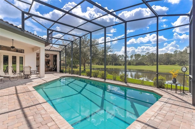 view of swimming pool with a patio area, ceiling fan, a water view, and a lanai