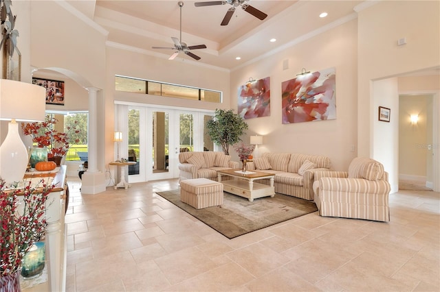 living room with ornamental molding, decorative columns, a high ceiling, and ceiling fan