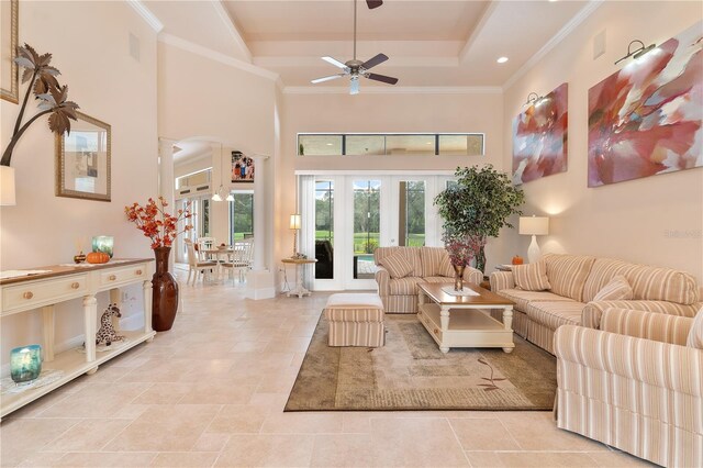 living room featuring french doors, crown molding, a towering ceiling, and ceiling fan