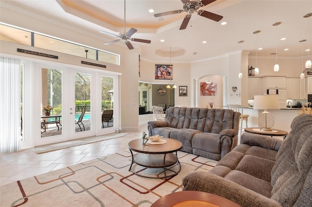 living room with french doors, ceiling fan, crown molding, and light tile patterned floors