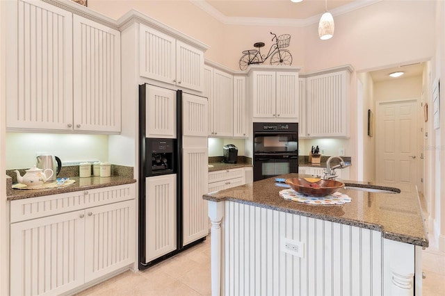 kitchen featuring sink, an island with sink, paneled refrigerator, crown molding, and black double oven