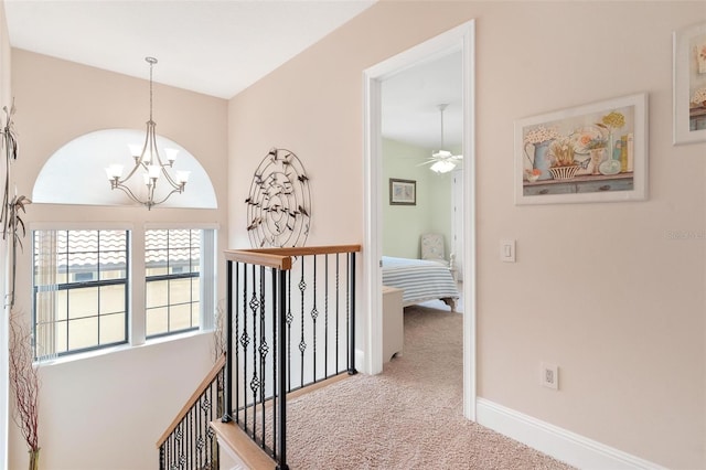 corridor featuring a chandelier and carpet flooring