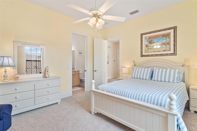 carpeted bedroom with ceiling fan and ensuite bath