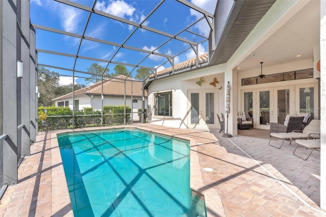 view of pool featuring french doors, ceiling fan, a lanai, and a patio