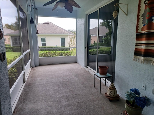 unfurnished sunroom featuring ceiling fan