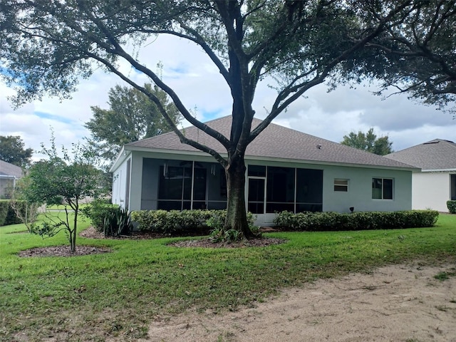 rear view of property featuring a sunroom and a yard