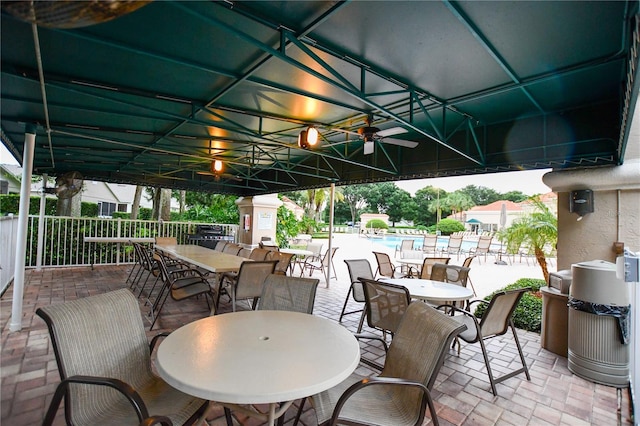 view of patio with a community pool and ceiling fan