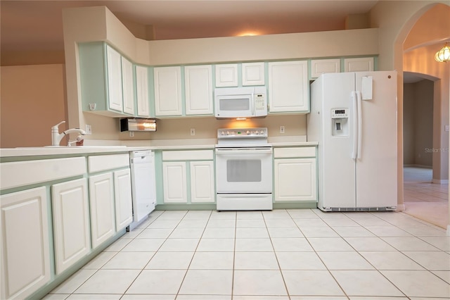 kitchen featuring light countertops, light tile patterned flooring, white cabinets, white appliances, and a sink