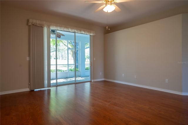 spare room featuring ceiling fan, baseboards, and wood finished floors