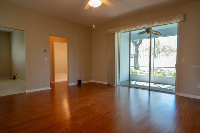 empty room featuring wood finished floors, a ceiling fan, and baseboards