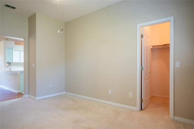 unfurnished bedroom featuring a spacious closet, carpet, and baseboards