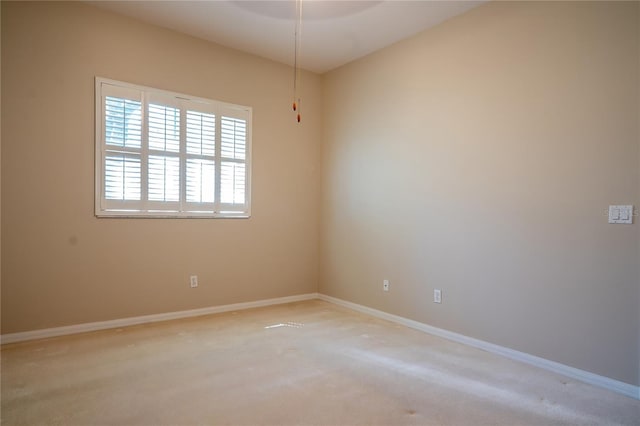 unfurnished room with light carpet and baseboards