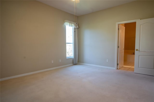 carpeted spare room featuring baseboards