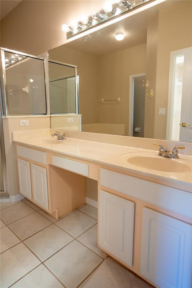 full bathroom with tile patterned floors, double vanity, a shower stall, and a sink