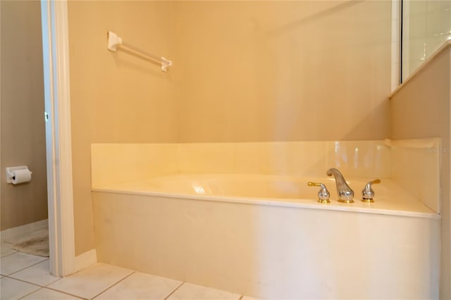 bathroom with tile patterned floors and a bath