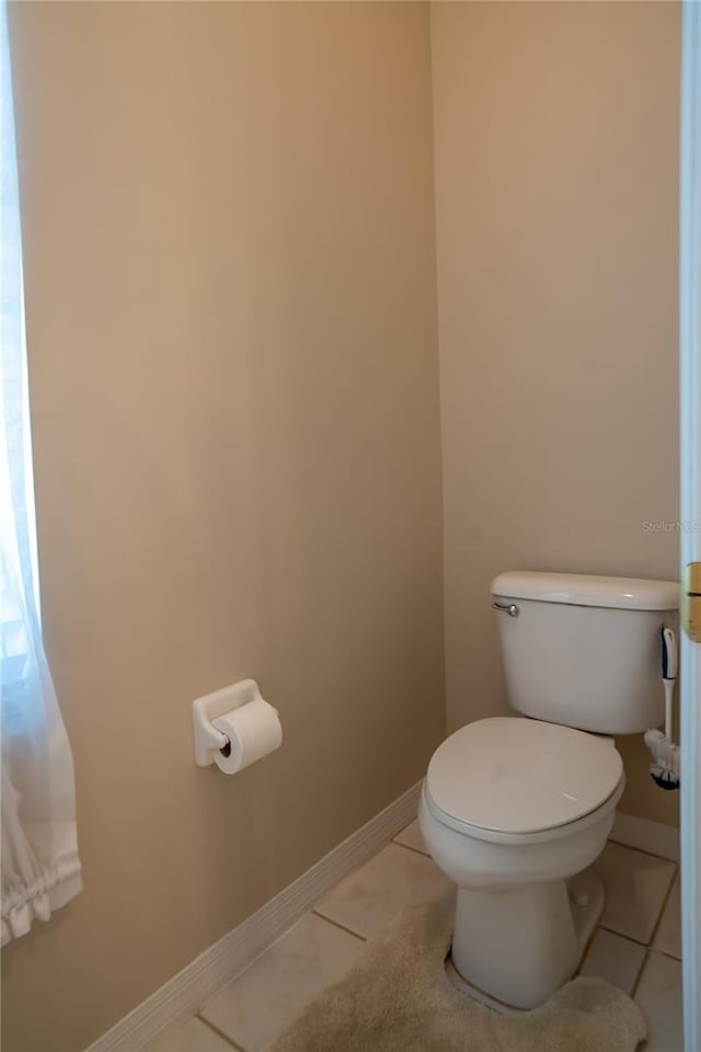 bathroom with tile patterned flooring, toilet, and baseboards