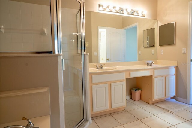 full bathroom featuring tile patterned flooring, a shower stall, double vanity, and a sink