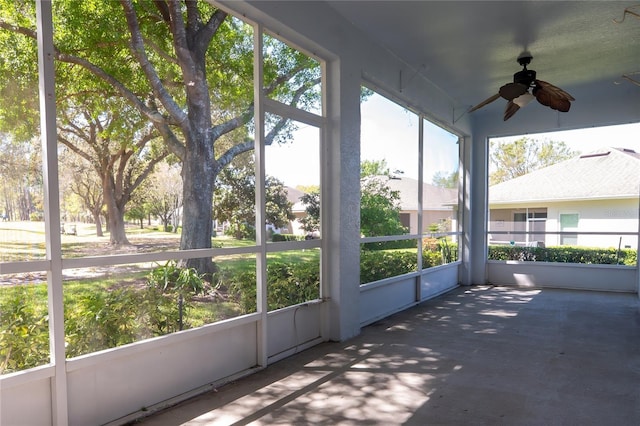 unfurnished sunroom with a ceiling fan