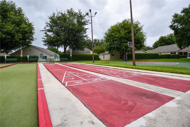 view of community featuring shuffleboard and a yard