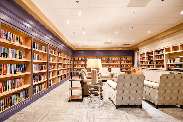 living area featuring recessed lighting and wall of books