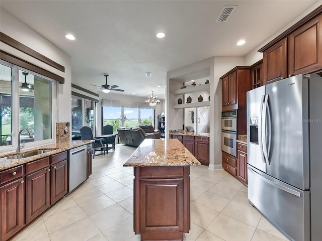 kitchen featuring light tile patterned flooring, stainless steel appliances, sink, and a kitchen island