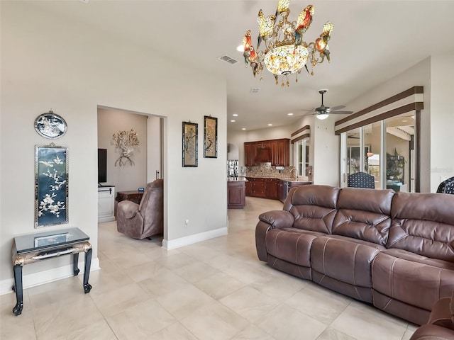 tiled living room with sink and ceiling fan with notable chandelier