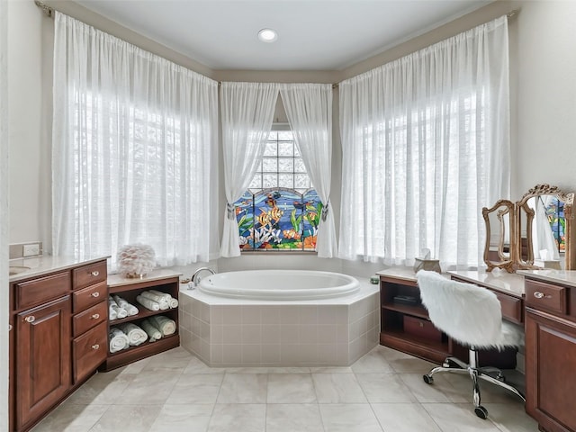 bathroom with vanity and tiled bath