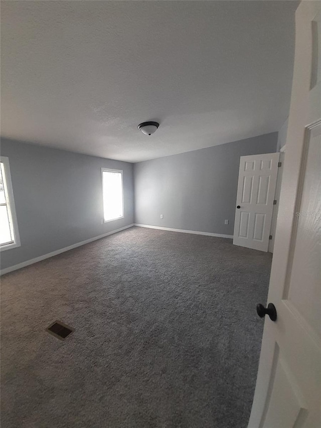 empty room with dark colored carpet