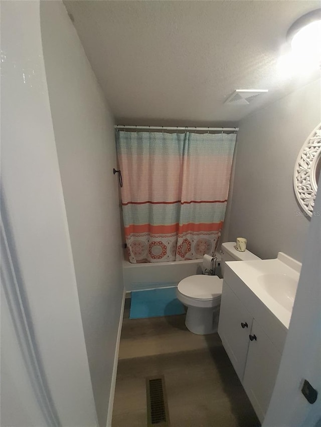 full bathroom with shower / bath combo with shower curtain, vanity, a textured ceiling, and toilet