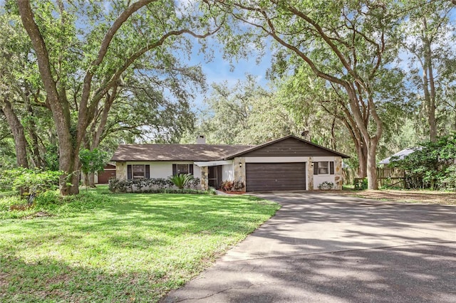 ranch-style house featuring a front lawn and a garage